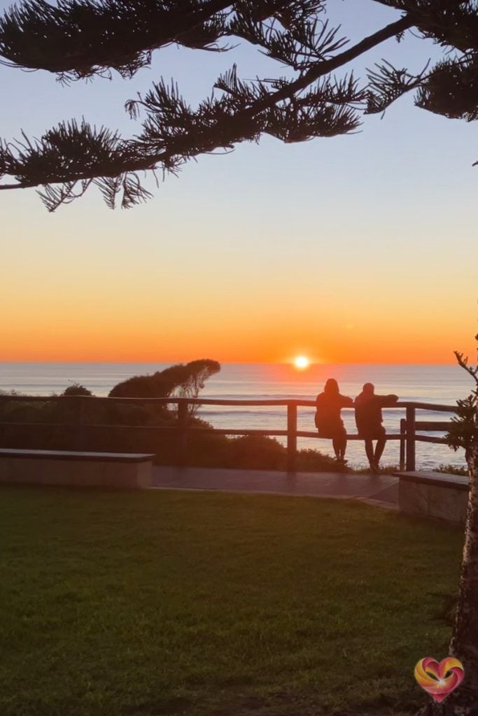 Silhouettes of a couple enjoying a peaceful sunset by the water